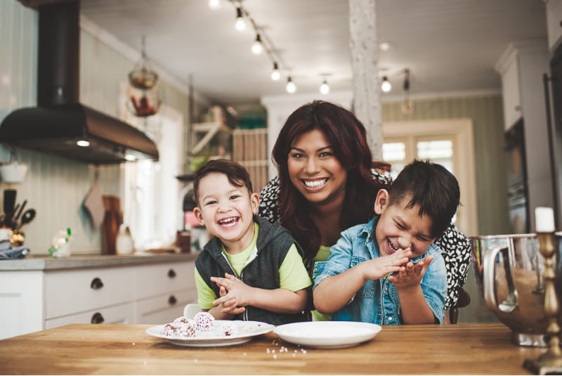 mother and children baking together and smiling